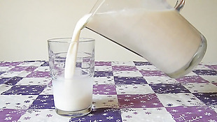 动态往桌子上的玻璃杯里倒牛奶视频实拍素材